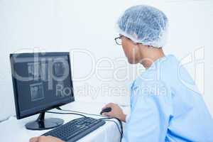 Dentist looking at x-ray on computer