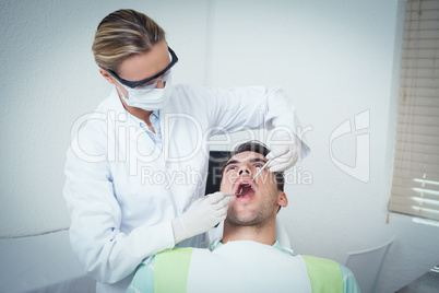 Female dentist examining mans teeth