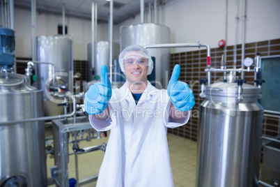 Positive man in lab coat giving thumbs up