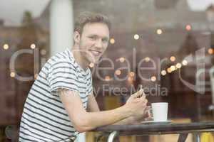 Smiling student sitting with a hot drink