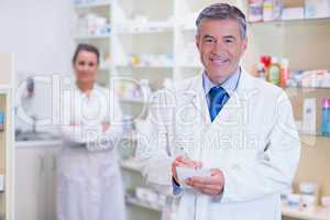 Pharmacist and his trainee with arms crossed behind