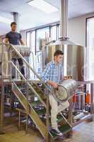 Young men carrying keg smiling at camera