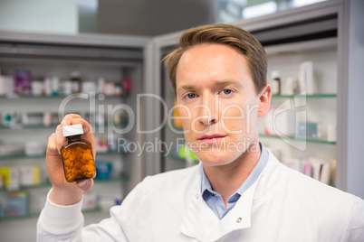 Handsome pharmacist holding medicine jar