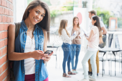 Pretty student smiling at camera with classmates behind