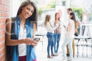 Pretty student smiling at camera with classmates behind