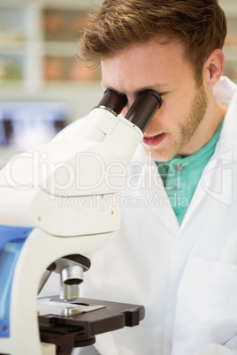 Young scientist working with microscope