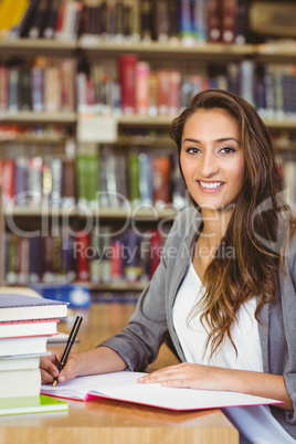 Smiling brunette student doing her assignment