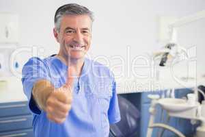 Portrait of happy dentist with thumbs up