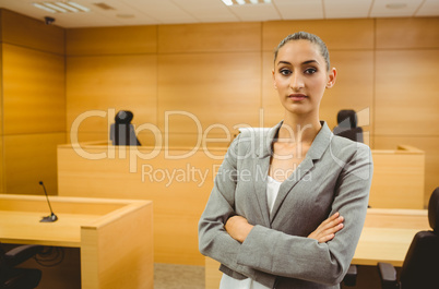 Unsmiling lawyer looking at camera crossed arms