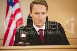 Portrait of a judge about to bang gavel on sounding block