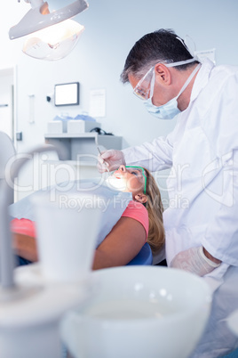 Dentist in surgical mask examining a patients teeth