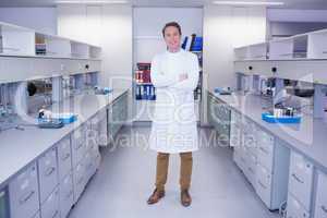 Portrait of a smiling biochemist standing with arms crossed