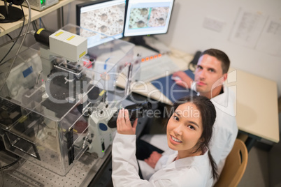 Biochemistry students using large microscope and computer