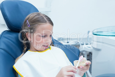 Little girl learning how to brush teeth