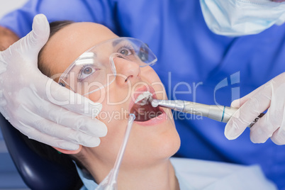 Dentist examining a patient with tools