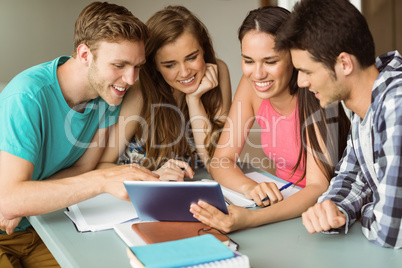 Smiling friends sitting using tablet pc