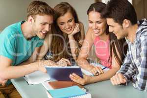 Smiling friends sitting using tablet pc