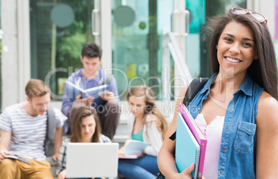 Pretty student smiling at camera outside