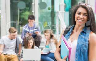 Pretty student smiling at camera outside