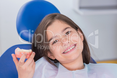 Portrait of a smiling young patient showing model