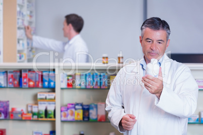 Concentrating pharmacist reading label on medicine jar