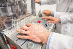 Pharmacist pressing button on machine