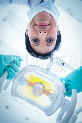 Low angle of female dentist adjusting light