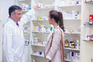 Pharmacist taking medicine in shelf