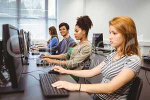 Happy student in computer class smiling at camera