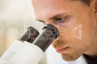 Young scientist working with microscope