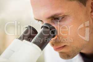 Young scientist working with microscope