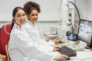 Science students working with microscopic image on computer