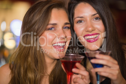 Pretty friends drinking cocktails together