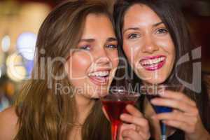 Pretty friends drinking cocktails together