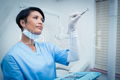 Female dentist holding dental tool