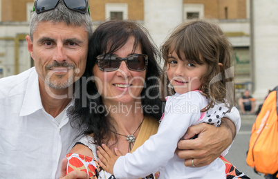 Father, mother and daughter happy together walking in the city