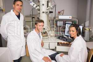 Biochemistry students using large microscope and computer