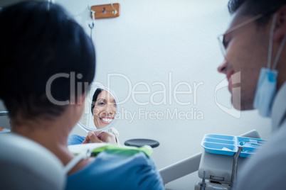 Smiling young woman looking at mirror