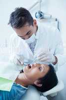 Male dentist examining womans teeth