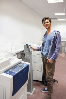 Smiling student standing next to the photocopier