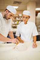 Team of bakers kneading dough