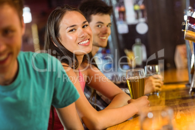 Smiling friends talking and drinking beer