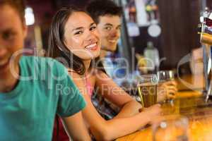 Smiling friends talking and drinking beer