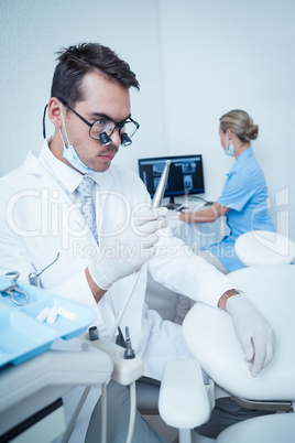 Dentist looking at dental drill