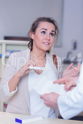 Shocked woman holding pregnancy test