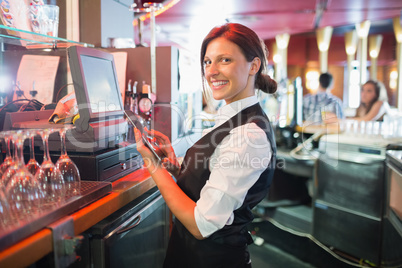 Pretty barmaid using touchscreen till