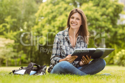 Smiling student sitting and holding a book