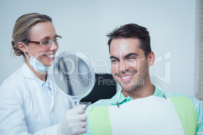 Smiling young man looking at mirror