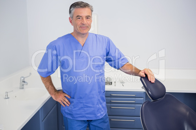 Portrait of a friendly dentist near dentists chair