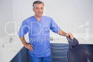 Portrait of a friendly dentist near dentists chair